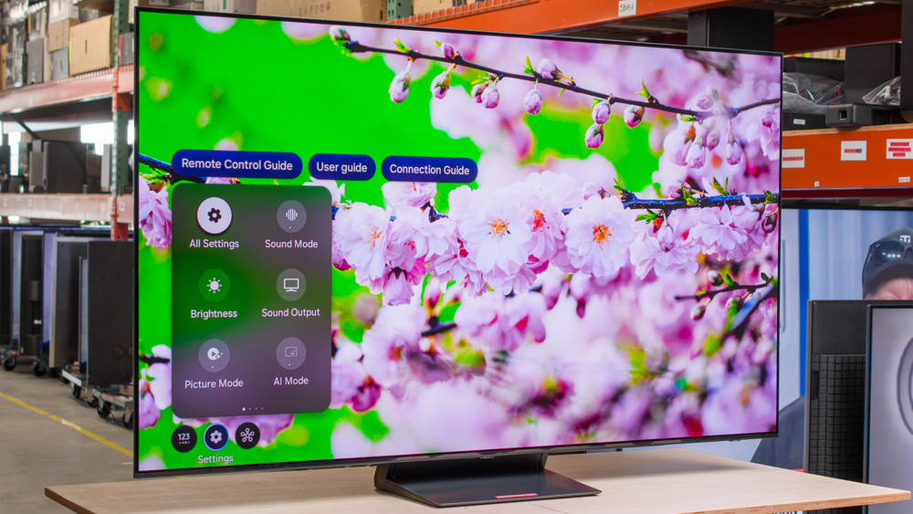 Modern smart TV displaying vibrant floral image with on-screen settings menu in a showroom